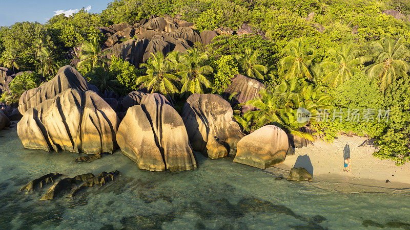 Anse Source d'Argent，塞舌尔，一对年轻的男女在热带海滩上